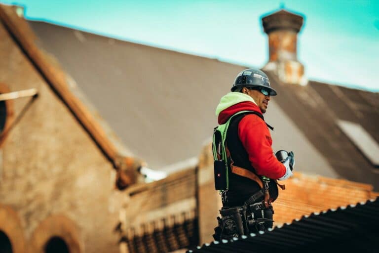 man in black helmet and red and black jacket standing on brown concrete stairs during daytime by Roofing Contractor in Stuart, FL.